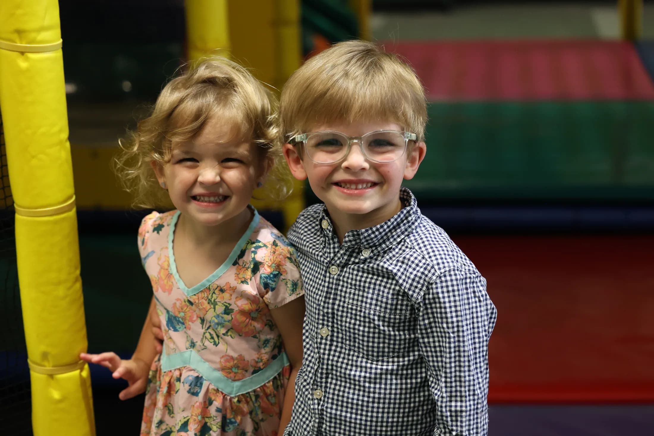 Two children smile together in the First Kids play area.