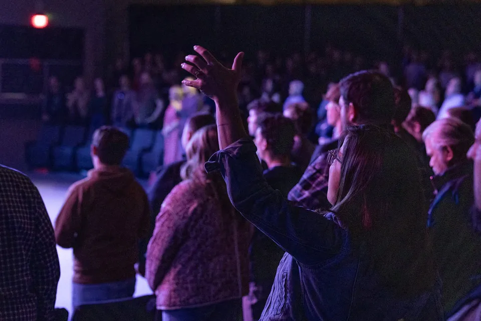 A worshipper raises her hands during a First Bossier gathering.